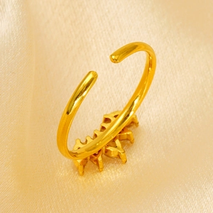 Macro shot of gold adjustable star cluster ring on luxurious yellow silk fabric