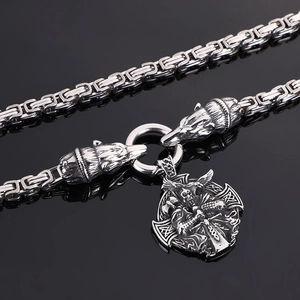 Detailed close-up of a silver Viking warrior pendant with wolf heads and square chain