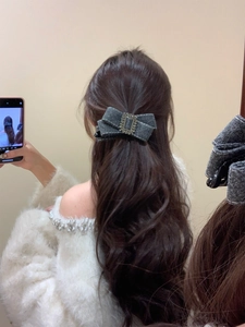 Détail d'une pince à cheveux nœud en laine grise avec boucle rectangulaire en cristal