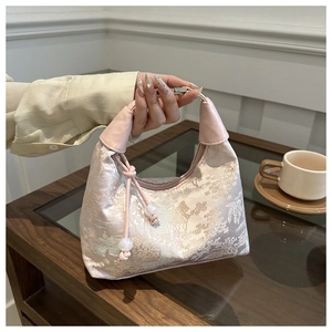 Detail of pink floral jacquard bucket bag featuring elegant beaded drawstring closure