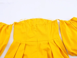 Detail of yellow off-shoulder dress featuring elastic neckline and hidden back zipper closure