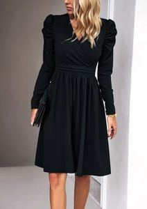 Detailed close-up of V-neckline and elegant pleated shoulder design on a black long sleeve dress