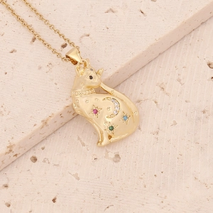 Macro detail of gold cat pendant with colorful gemstones and moon star patterns