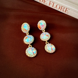 Détail de boucles d'oreilles vintage dorées avec cristaux AB et pavé de diamants
