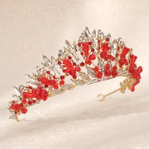 Macro detail of gold bridal crown with red rhinestones and crystal accents