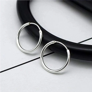 Polished silver titanium steel hoop earrings in a minimalist circular design on white background
