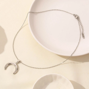 Polished stainless steel moon necklace detail with lobster clasp and extender chain