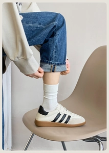 Close-up of retro leather sneakers with grey suede toe and contrast rubber gum sole