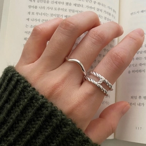 Close-up of stacked S925 sterling silver rings with twisted texture and wave design