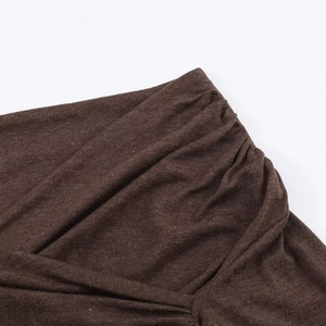 Close-up of the pleated details and soft knit texture of the dark brown ruched top