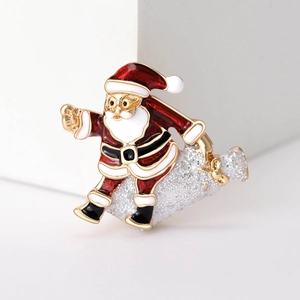 Detail of red and white Santa Claus brooch with gold edges and glitter bag on white pedestal