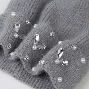 Detailed macro view of gray knit beanie with delicate faux pearls and crystal rhinestones