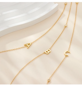 Close-up of golden S925 silver alphabet pendants with sparkling zircon stone settings