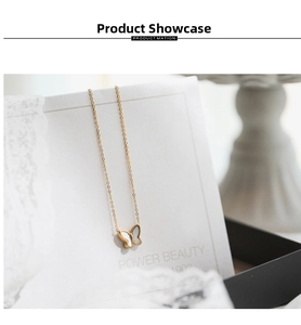 Close-up of golden butterfly pendant with white shell inlay on a white jewelry card