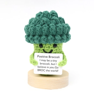 Close-up of a handmade crochet positive broccoli with card on a wooden base