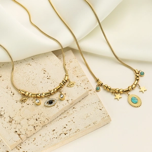 Gold plated stainless steel necklaces with turquoise and evil eye pendants on stone