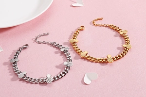 Detailed macro view of gold and silver pineapple charms on thick stainless steel curb chains