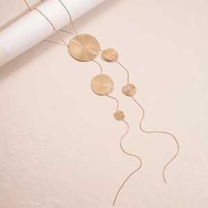 Detail view of gold sweater necklace with five textured spiral circular pendants