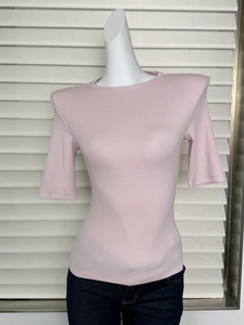 Detail view of pink slim-fit t-shirt showing shoulder pads and round neck texture