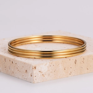 Three-piece stackable gold stainless steel bangle set with polished mirror finish