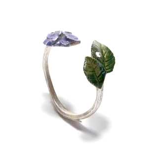 Detail of adjustable ring featuring purple flower and green leaves with rhinestone
