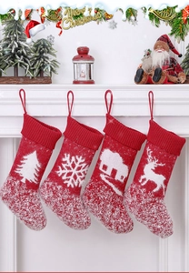 Detail of red and white knitted Christmas stockings with reindeer and tree patterns
