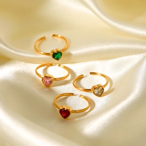Detail of colorful heart-shaped crystal rings on a luxury silk background