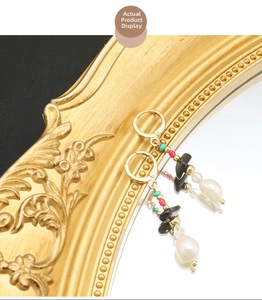 Detail of baroque pearl and black agate earrings with gold plating and turquoise beads
