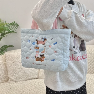 Detail of light blue quilted tote bag with cute dog embroidery and pink handles