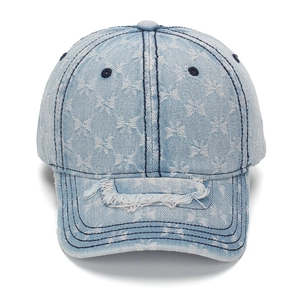 Distressed light blue denim baseball cap with white bow patterns and ripped brim detail