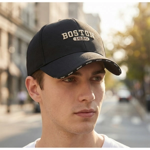 Detail of embroidered BOSTON 1630 logo and SPORT lettering on a black baseball cap