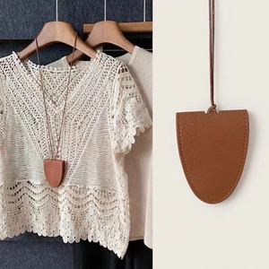 Braune magnetische Leder-Brillenkette mit weißem Häkeloberteil und einem Holzkleiderbügel