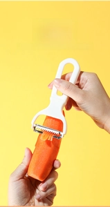 Close-up of dual stainless steel blades shredding a carrot into fine even strips