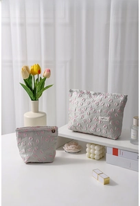 Set of grey floral embroidered cosmetic bags featuring pink tulips and elegant accessories