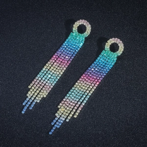 Macro detail of long tassel earrings with sparkling rainbow gradient rhinestones