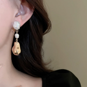 Boucles d'oreilles perles baroques style français et détails dorés portées par un modèle