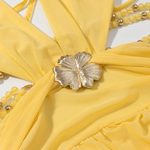 Close-up of yellow mesh dress with gold flower buckle and beaded strap detail