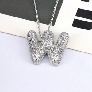 Macro view of silver 3D letter W pendant with pavé cubic zirconia on bead chain