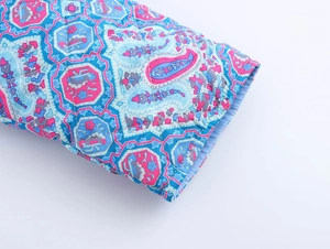 Detail of quilted cuff showing colorful paisley pattern and geometric prints on fabric