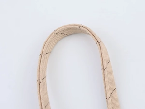 Détail de la sangle en toile beige avec surpiqûres en losanges marron foncé