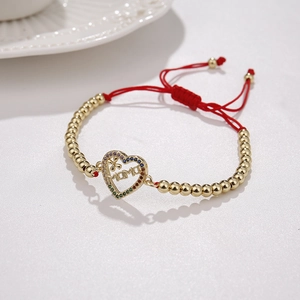 Detail view of MAMA heart pendant on red braided rope bracelet with gold beads