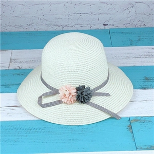 Close-up of kids straw sun hat with grey polka dot ribbon and dual fabric flower accents