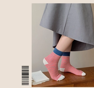 Gros plan sur des chaussettes rétro en coton rayé rouge et blanc avec des poignets bleus
