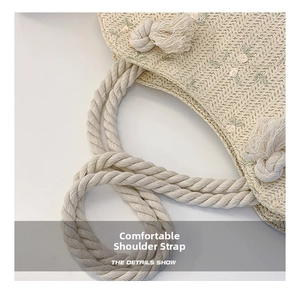 Gros plan du sac cabas tissé beige avec broderie florale et détails de bandoulière en corde