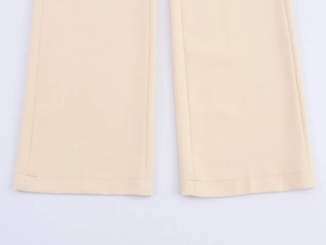 Detailed view of apricot suit trousers leg featuring clean hemline and smooth fabric