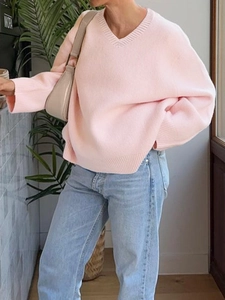 Detail of pink V-neck knit sweater in loose fit style with comfortable texture and casual look