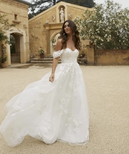 Détail de la broderie sur robe de mariée blanche à col cœur et jupe en tulle multicouche