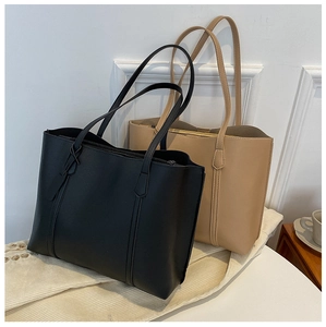 Detail view of large soft PU leather tote bags in black and beige for daily commute