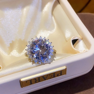 Macro shot of silver zircon sunflower ring set in a premium white jewelry box