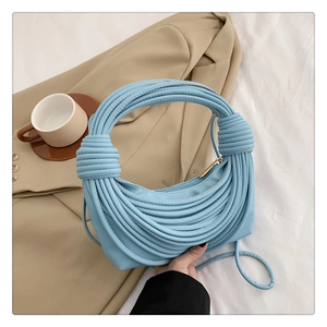 Close-up of sky blue knotted hobo bag with rope design on a white cloth background